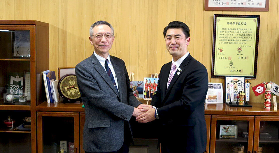 山田裕一市長（右）と握手する片平美明先生（左）